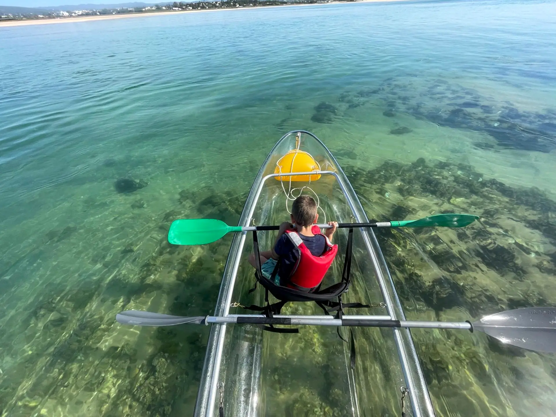 Clear kayak with seagrass visible through the transparent hull