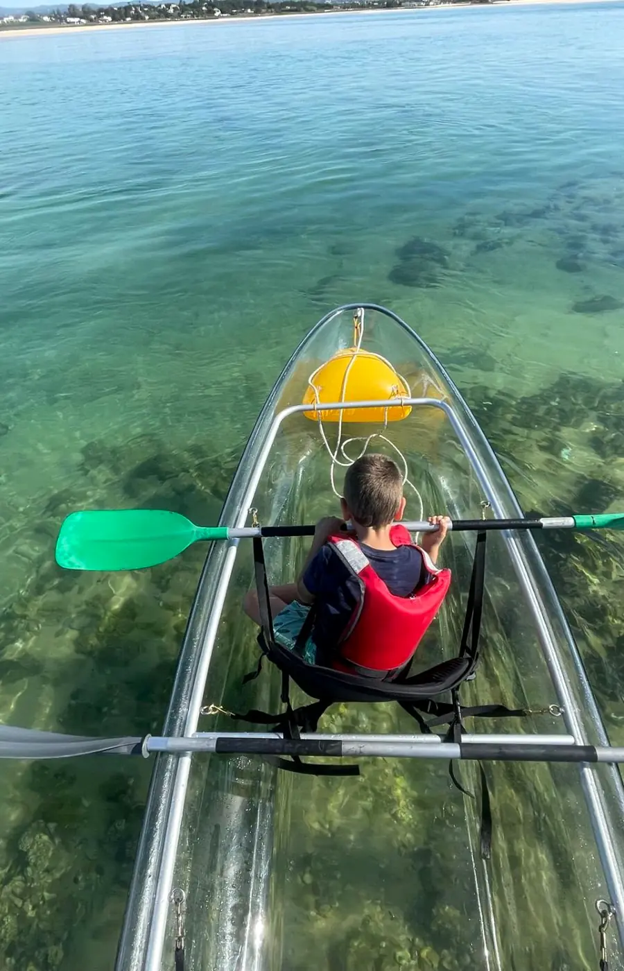 Clear kayak with seagrass visible through the transparent hull